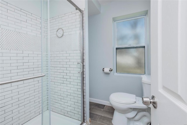 full bath with baseboards, toilet, and a shower stall