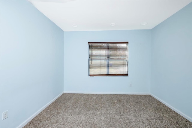 spare room featuring carpet flooring and baseboards