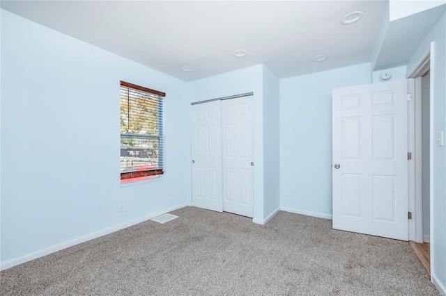 unfurnished bedroom with a closet, baseboards, and carpet floors