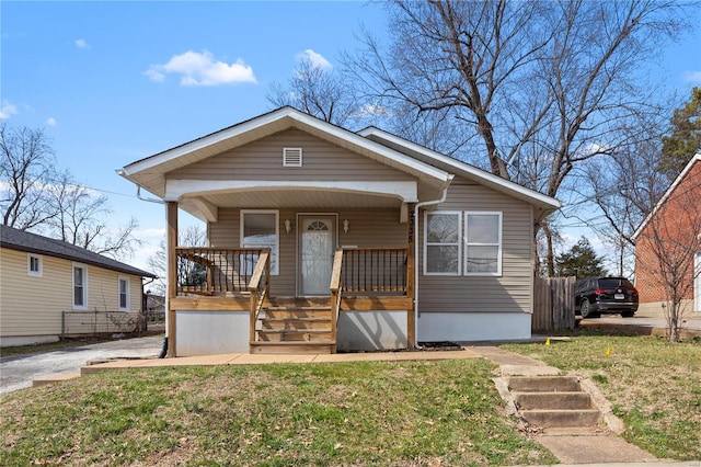 bungalow-style house featuring covered porch and a front lawn