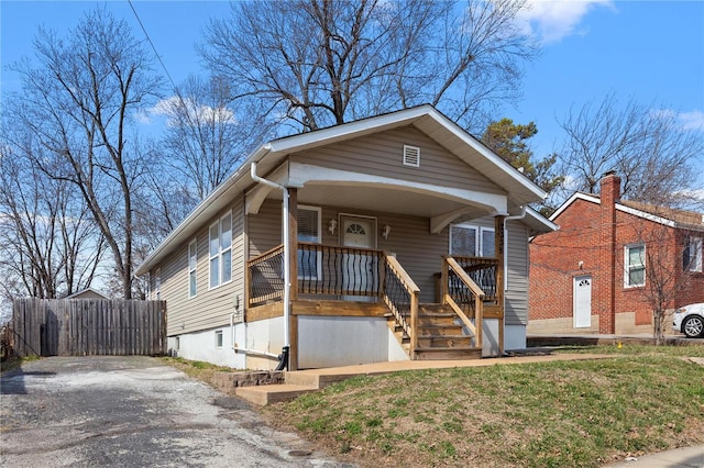 bungalow-style home with covered porch and fence