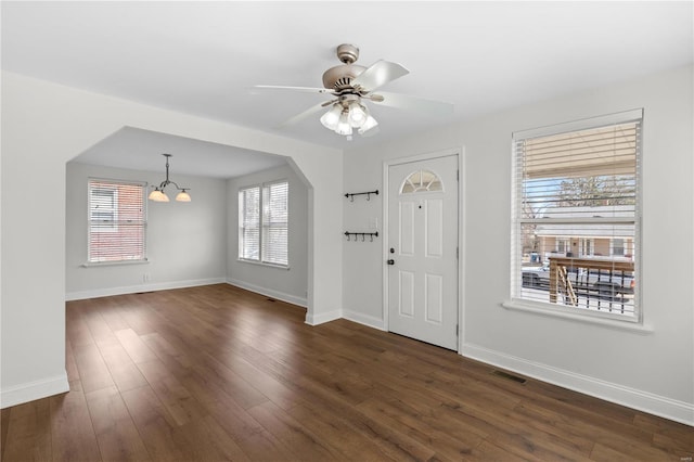 entryway featuring visible vents, baseboards, arched walkways, and dark wood-style floors