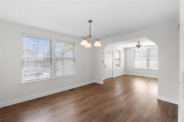 empty room featuring visible vents, baseboards, dark wood finished floors, and ceiling fan with notable chandelier