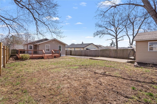 view of yard featuring a wooden deck, a fenced backyard, and a patio area