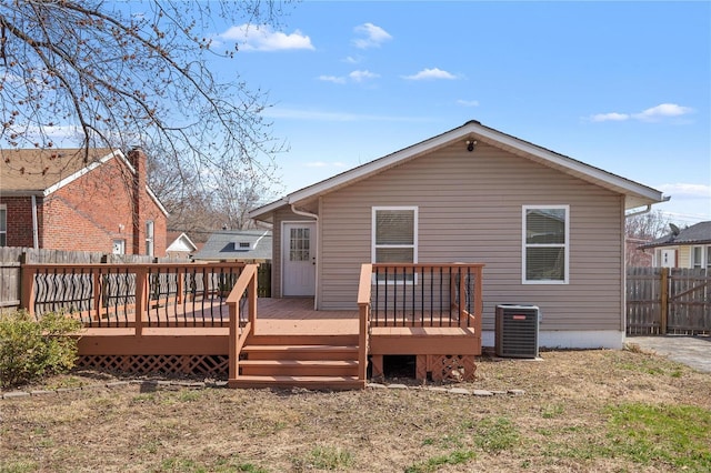 rear view of property with a deck, central AC unit, and a fenced backyard