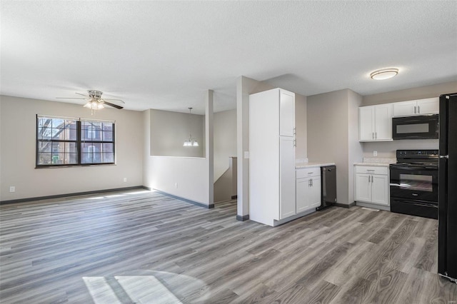 kitchen with light wood-type flooring, black appliances, a ceiling fan, white cabinetry, and light countertops