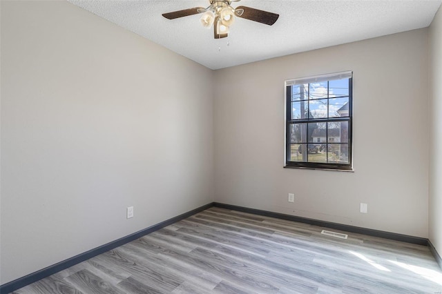 spare room featuring a textured ceiling, baseboards, and ceiling fan