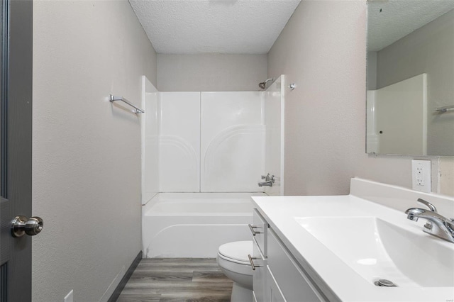 bathroom featuring toilet, shower / bath combination, vanity, wood finished floors, and a textured ceiling