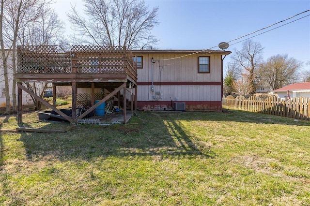 rear view of property with a lawn, a deck, fence, cooling unit, and stairs