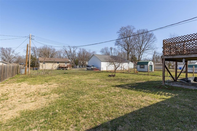 view of yard with a shed, an outdoor structure, and fence