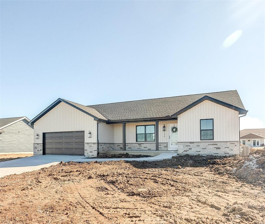 view of front facade featuring cooling unit, driveway, and a garage