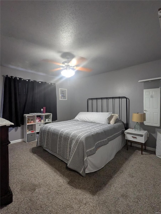 carpeted bedroom featuring baseboards, a textured ceiling, and a ceiling fan