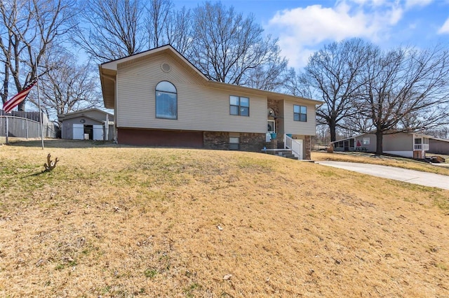 bi-level home with a front lawn and fence