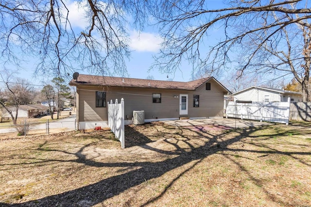 back of house featuring fence, central AC, a yard, a patio, and a gate