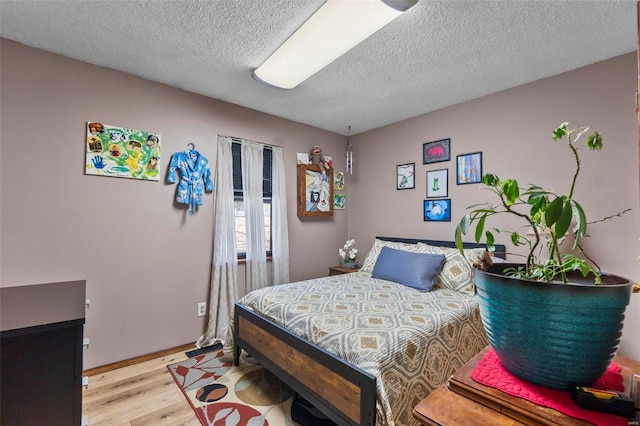 bedroom with light wood-style flooring and a textured ceiling