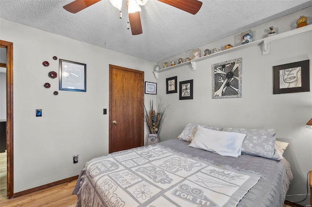 bedroom with baseboards, a textured ceiling, light wood-type flooring, and ceiling fan