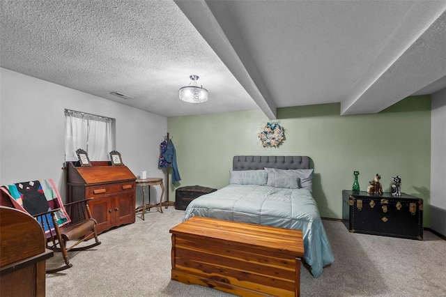 bedroom featuring visible vents, light colored carpet, and a textured ceiling