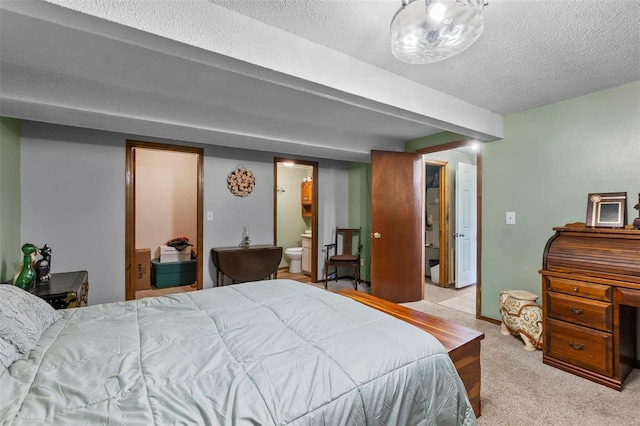 bedroom featuring carpet, ensuite bathroom, and a textured ceiling