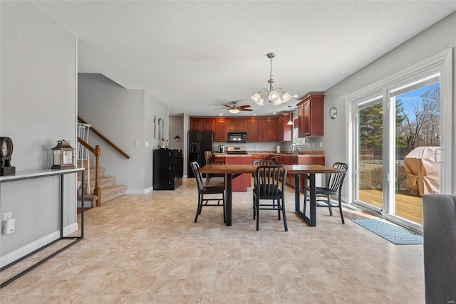 dining room featuring ceiling fan with notable chandelier, a textured ceiling, stairs, and baseboards