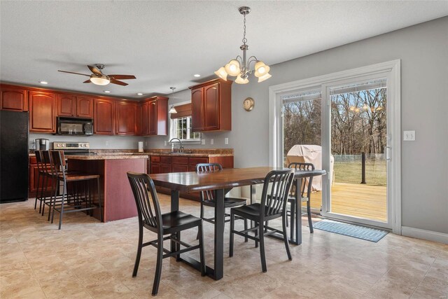 dining space with recessed lighting, ceiling fan with notable chandelier, a textured ceiling, and baseboards