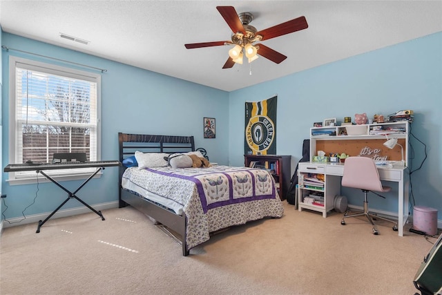 carpeted bedroom featuring visible vents, baseboards, a textured ceiling, and ceiling fan