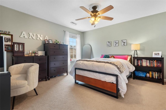 carpeted bedroom with a ceiling fan and visible vents