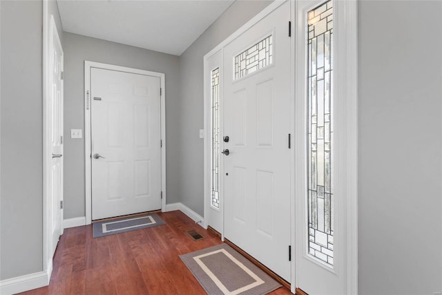 entrance foyer with visible vents, baseboards, and dark wood-style flooring