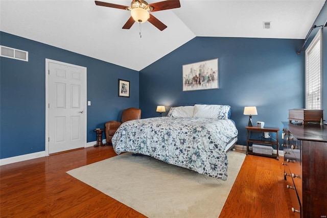 bedroom featuring a ceiling fan, wood finished floors, visible vents, baseboards, and vaulted ceiling