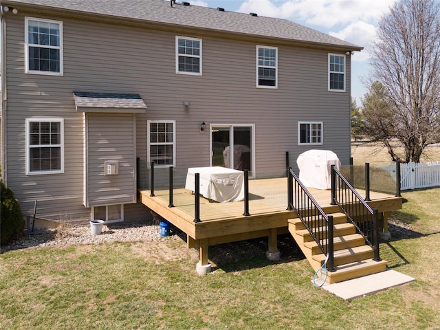 rear view of property with a yard, a shingled roof, a deck, and fence