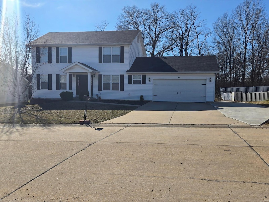 colonial inspired home featuring driveway, a garage, and fence