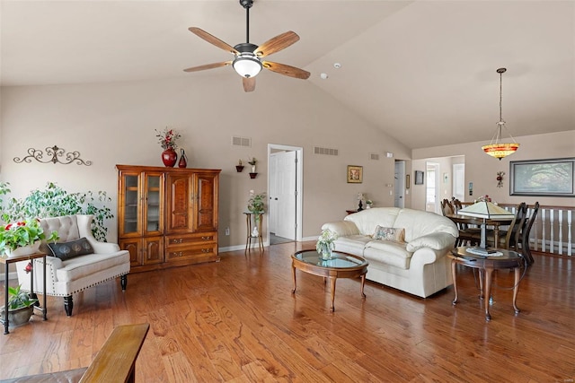 living area featuring light wood finished floors, visible vents, high vaulted ceiling, and ceiling fan