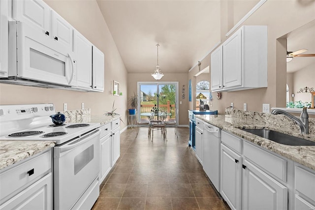 kitchen with white appliances, lofted ceiling, ceiling fan, a sink, and white cabinetry