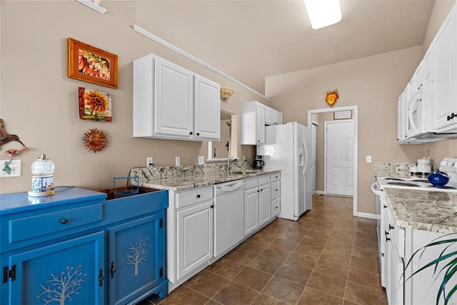 kitchen with white appliances, light stone counters, blue cabinetry, a sink, and white cabinets