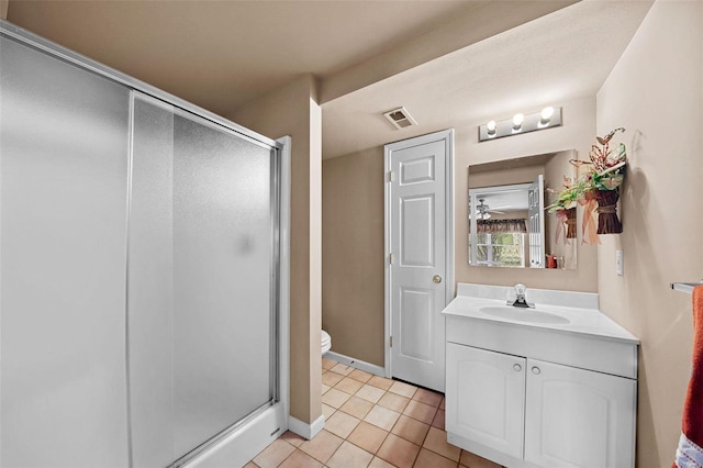 bathroom with tile patterned flooring, visible vents, a shower stall, toilet, and vanity