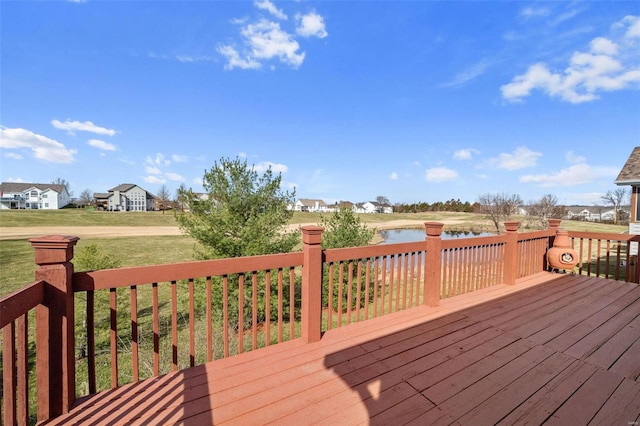 wooden terrace with a water view and a lawn