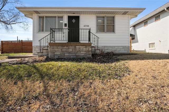 bungalow featuring fence