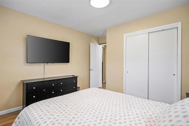 bedroom with a closet, baseboards, and wood finished floors