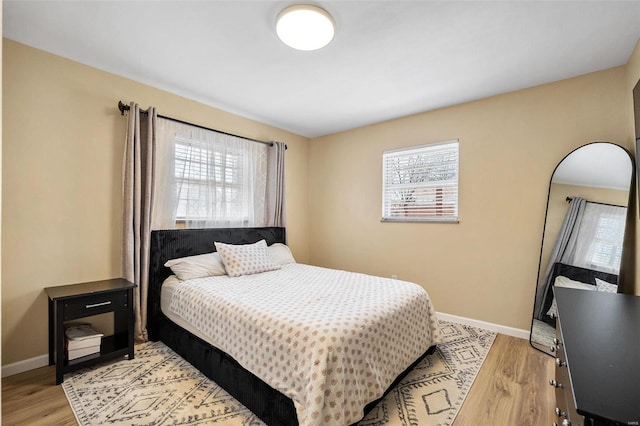 bedroom with light wood finished floors and baseboards