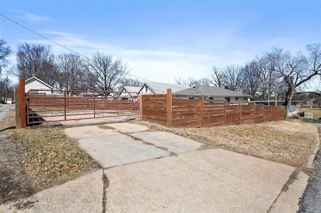 view of yard featuring a fenced front yard, concrete driveway, and a gate