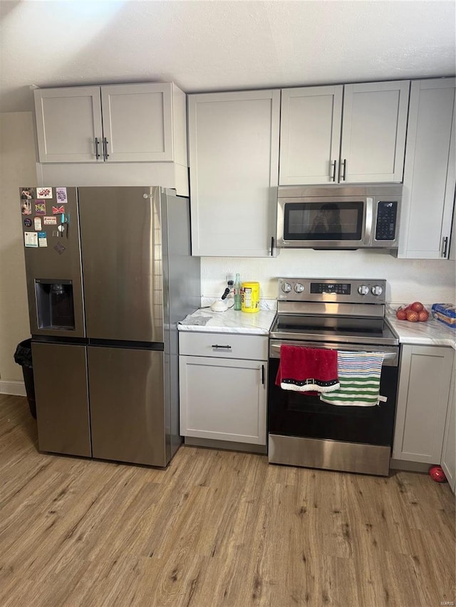 kitchen featuring appliances with stainless steel finishes, gray cabinets, and light countertops