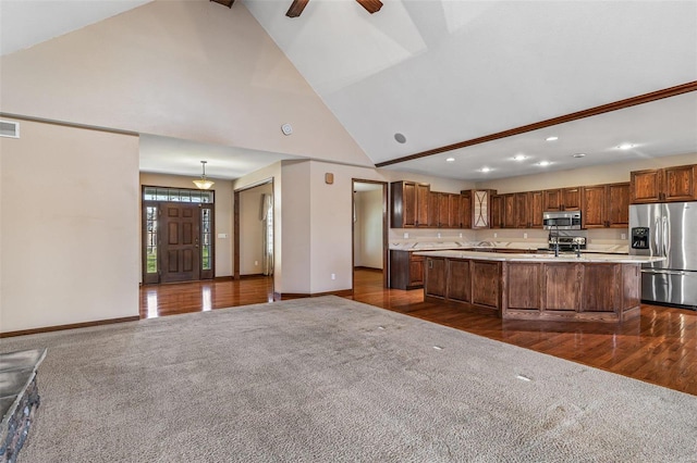 kitchen featuring visible vents, an island with sink, stainless steel appliances, light countertops, and dark carpet