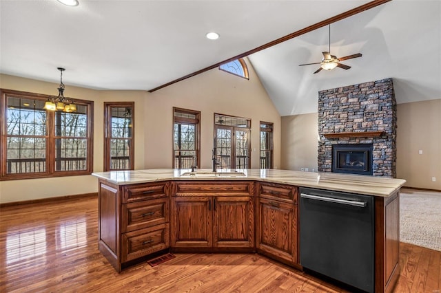 kitchen with open floor plan, dishwashing machine, ceiling fan with notable chandelier, light wood-style floors, and a sink