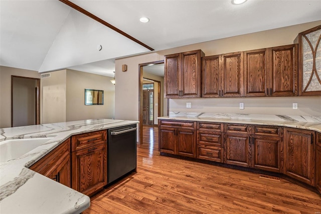 kitchen featuring visible vents, light wood-style flooring, light stone countertops, dishwasher, and vaulted ceiling