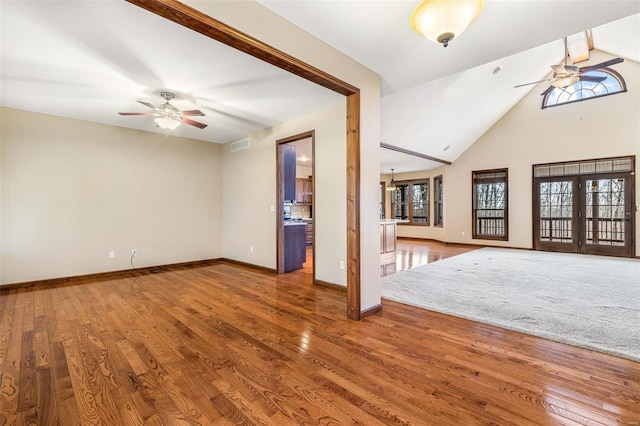 unfurnished living room with visible vents, wood finished floors, and ceiling fan