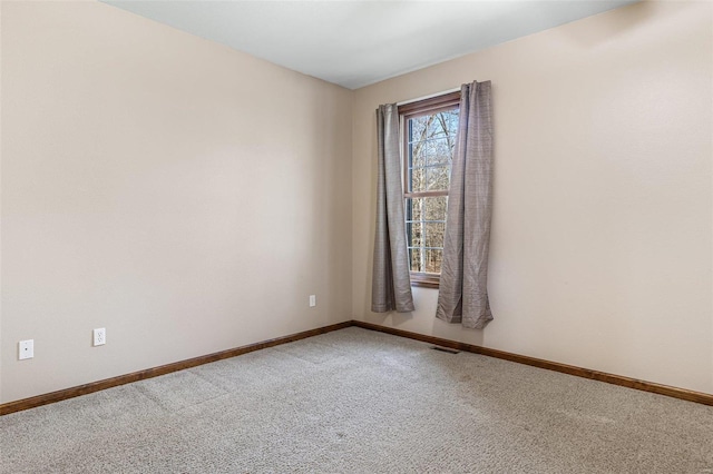 empty room featuring visible vents, baseboards, and carpet floors