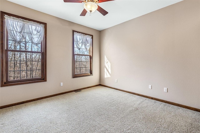 carpeted spare room with baseboards and ceiling fan