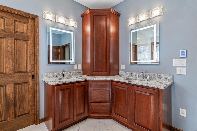 bathroom with double vanity, marble finish floor, and a sink