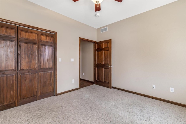 unfurnished bedroom featuring visible vents, baseboards, light colored carpet, and ceiling fan