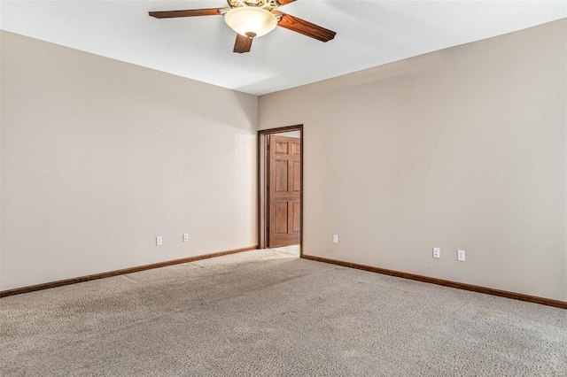 spare room featuring baseboards, light carpet, and a ceiling fan