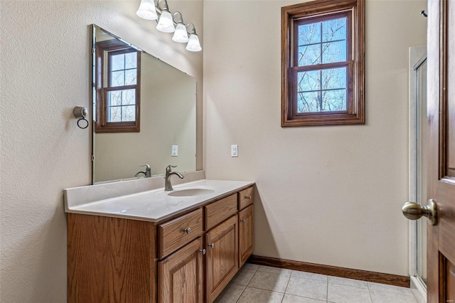 bathroom featuring an enclosed shower, baseboards, vanity, and tile patterned flooring